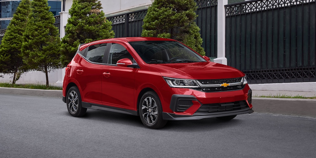 Vista delantera lateral de Chevrolet Aveo HB 2025, con faros de halógeno proyector y LED diurnas con direccional integrada